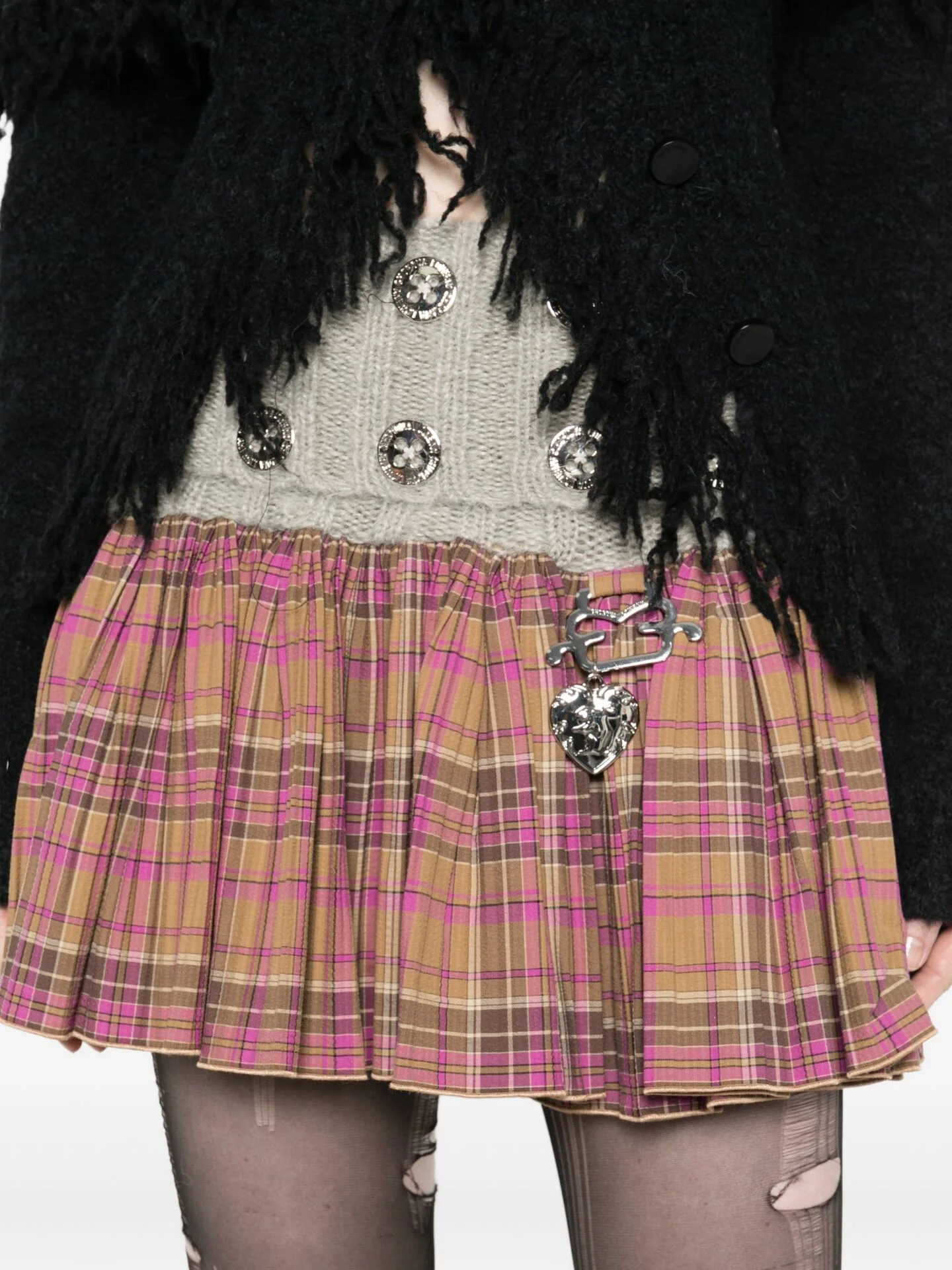Black shaggy coat over a cream cable knit and pink checked skirt