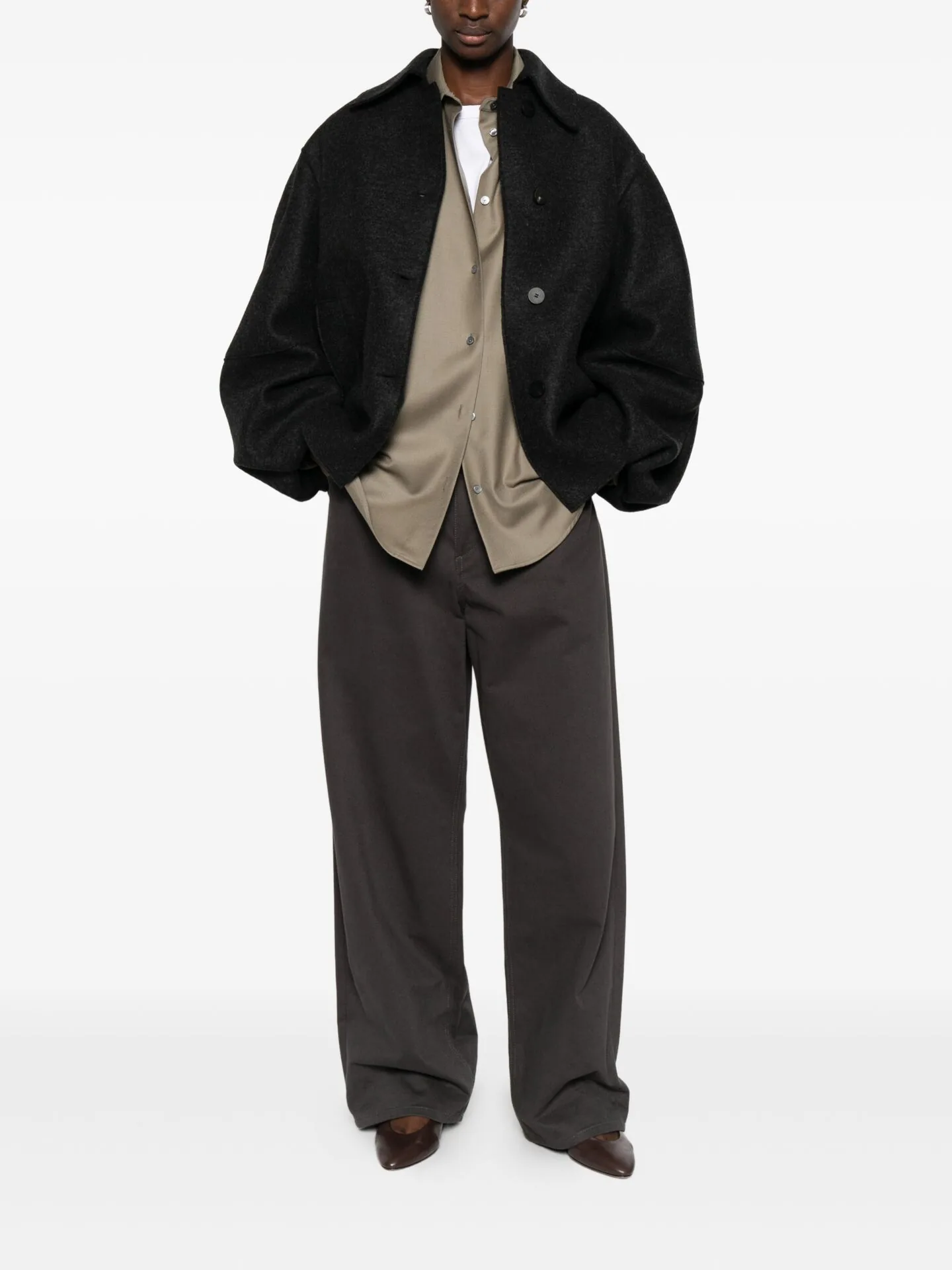 Oversized black jacket over a taupe shirt and wide grey trousers