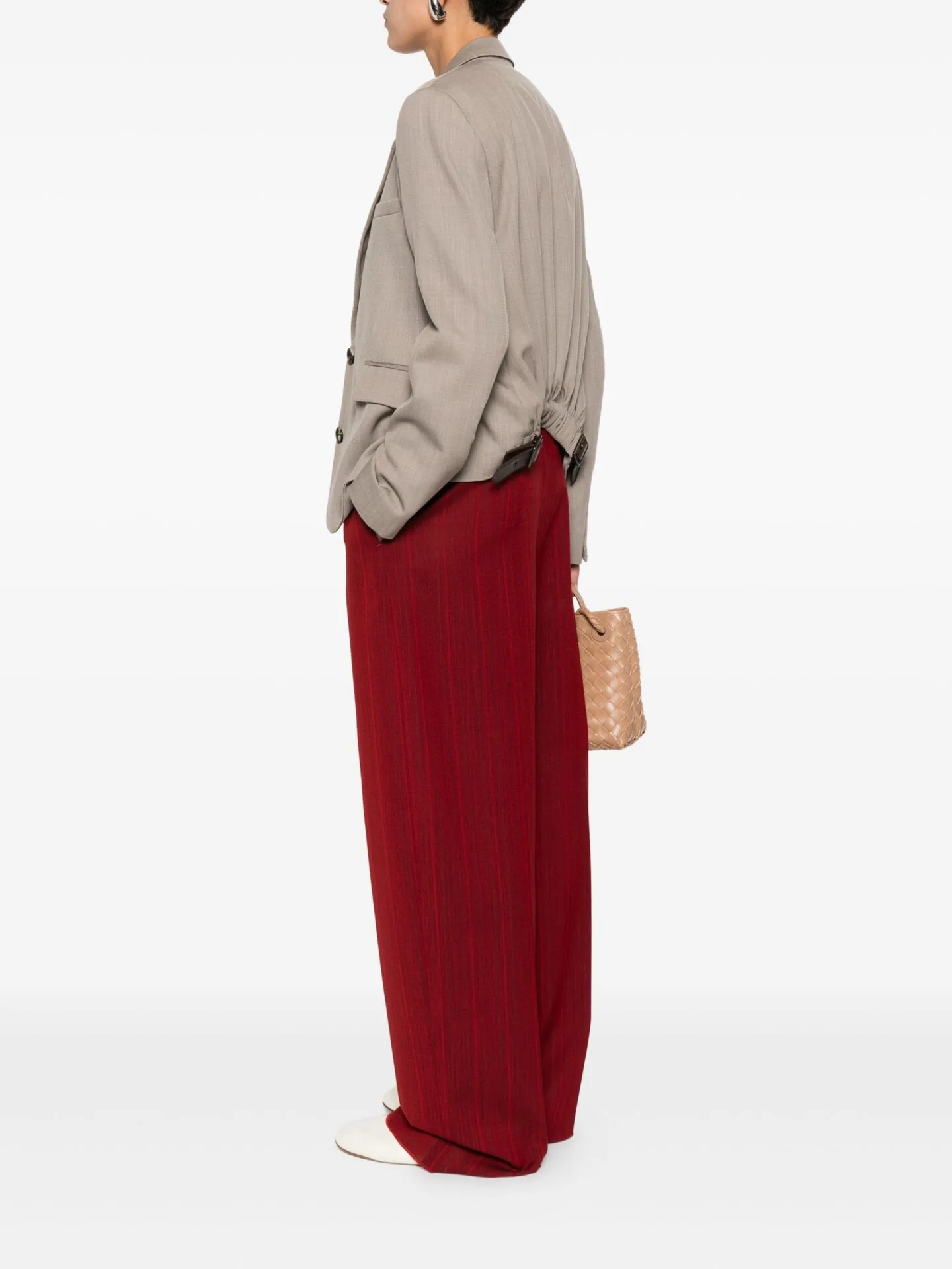 Back view of a grey shirt worn over a long red skirt with a straw bag