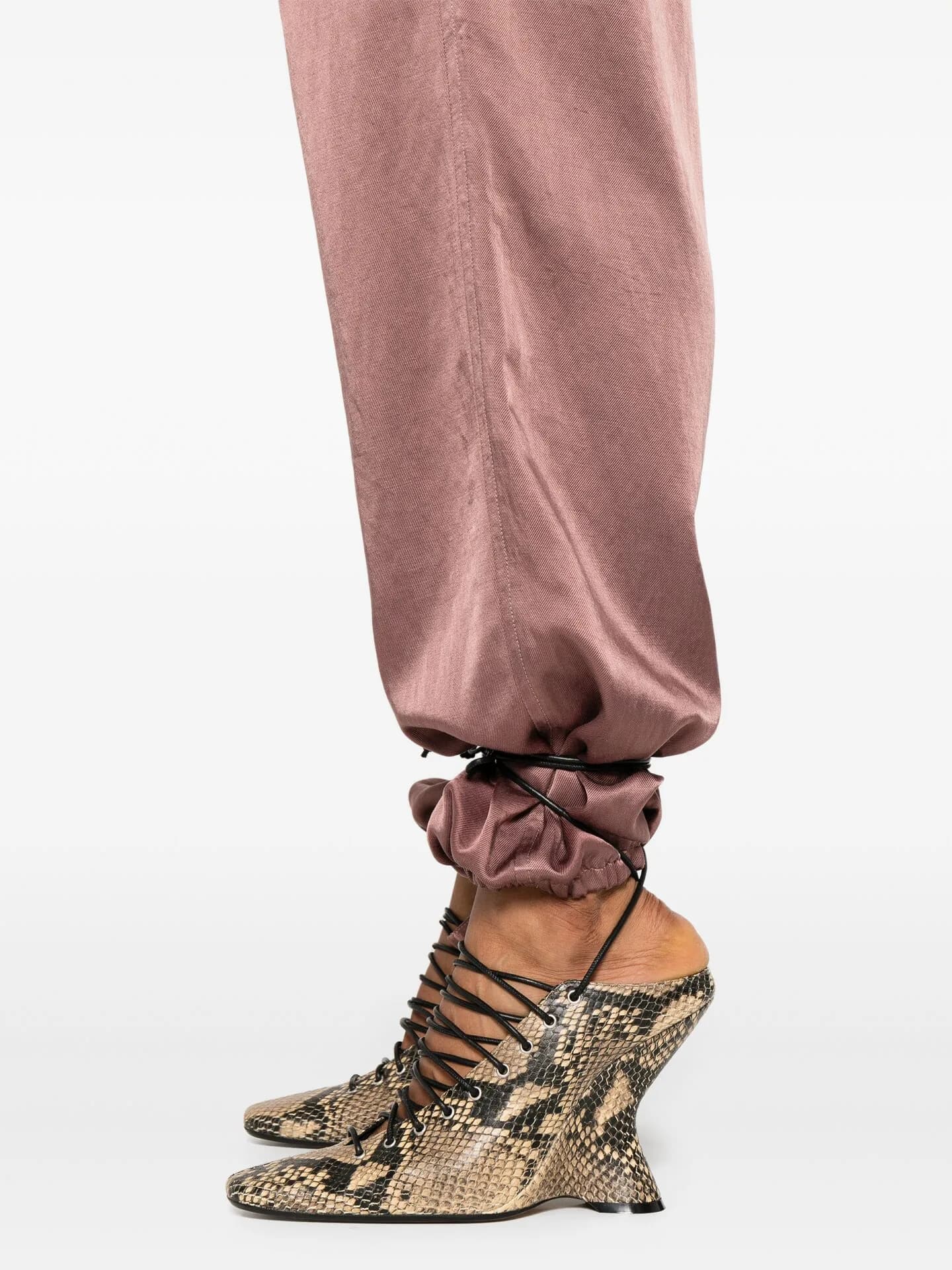Dusty pink satin trousers gathered over snakeskin lace-up wedge boots