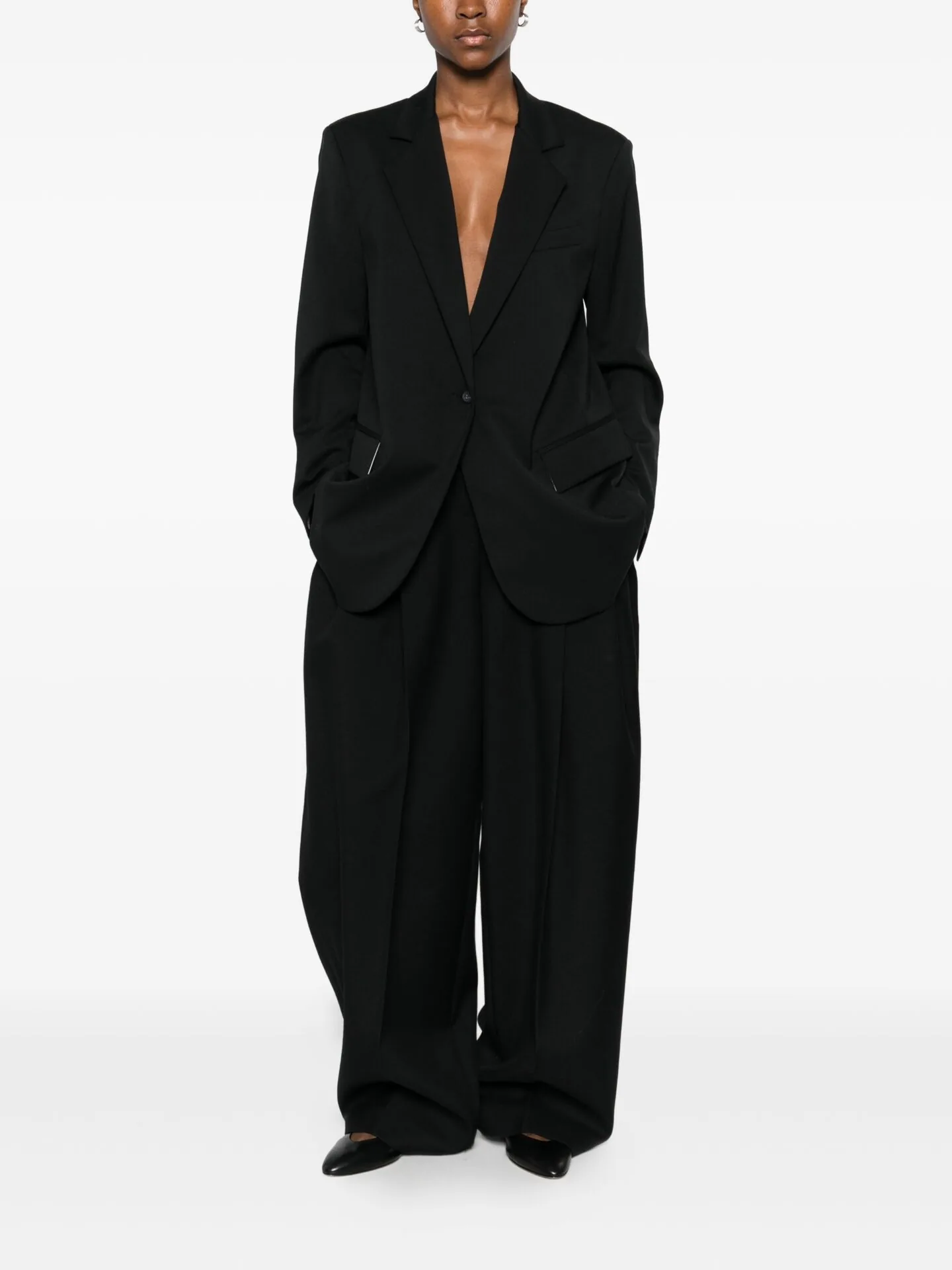 Oversized black blazer worn with wide black trousers