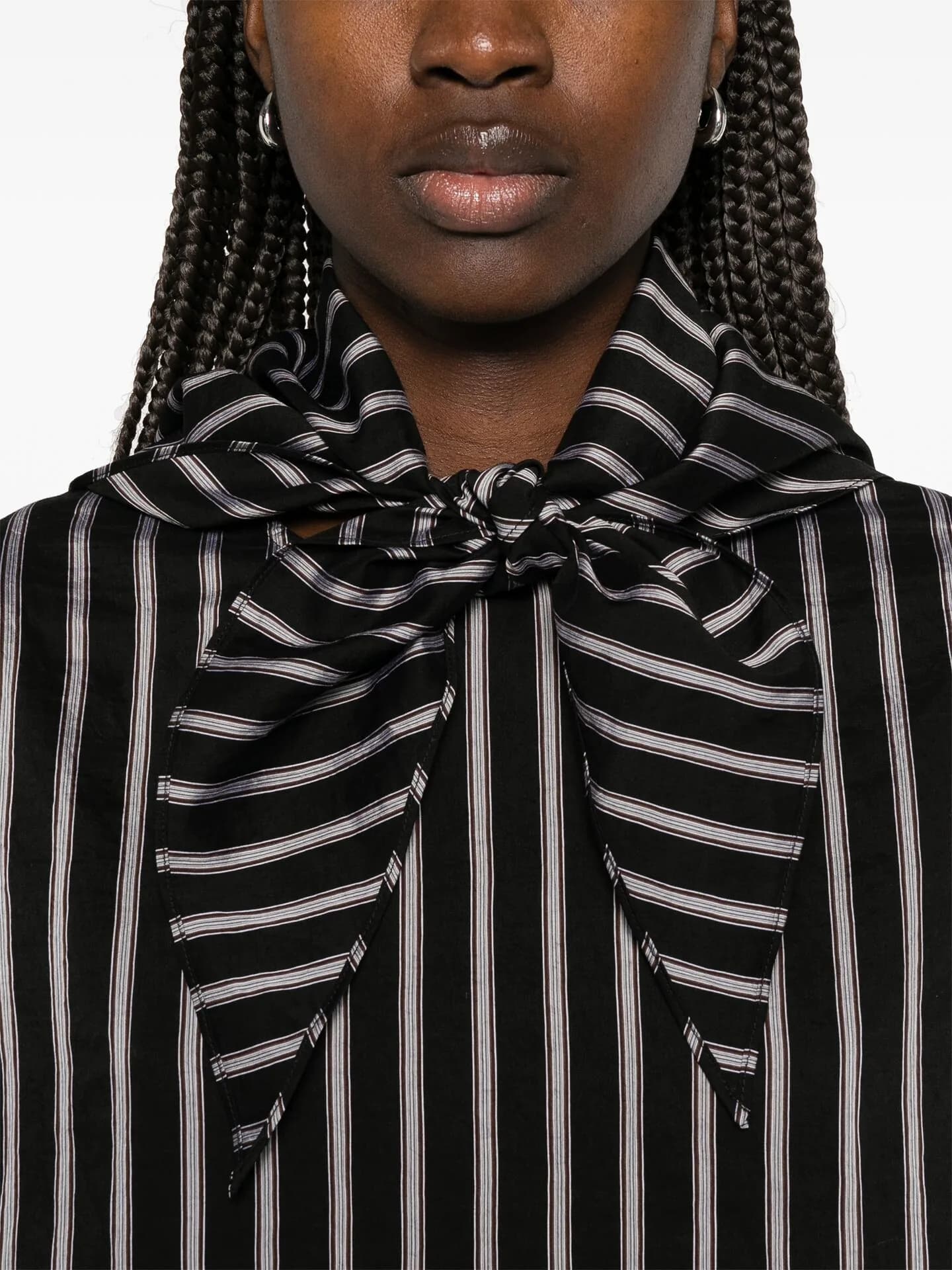 Close crop of a black and white striped shirt tied in a large pussy bow