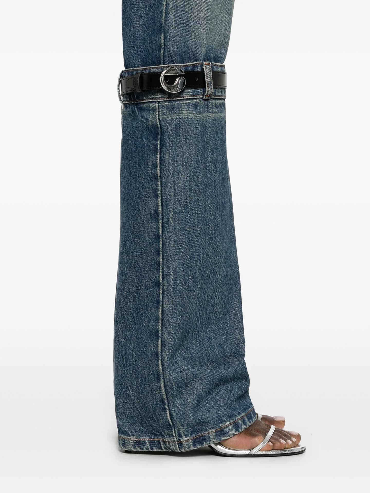 Close crop of wide-leg jeans with a belt fastened around the calf