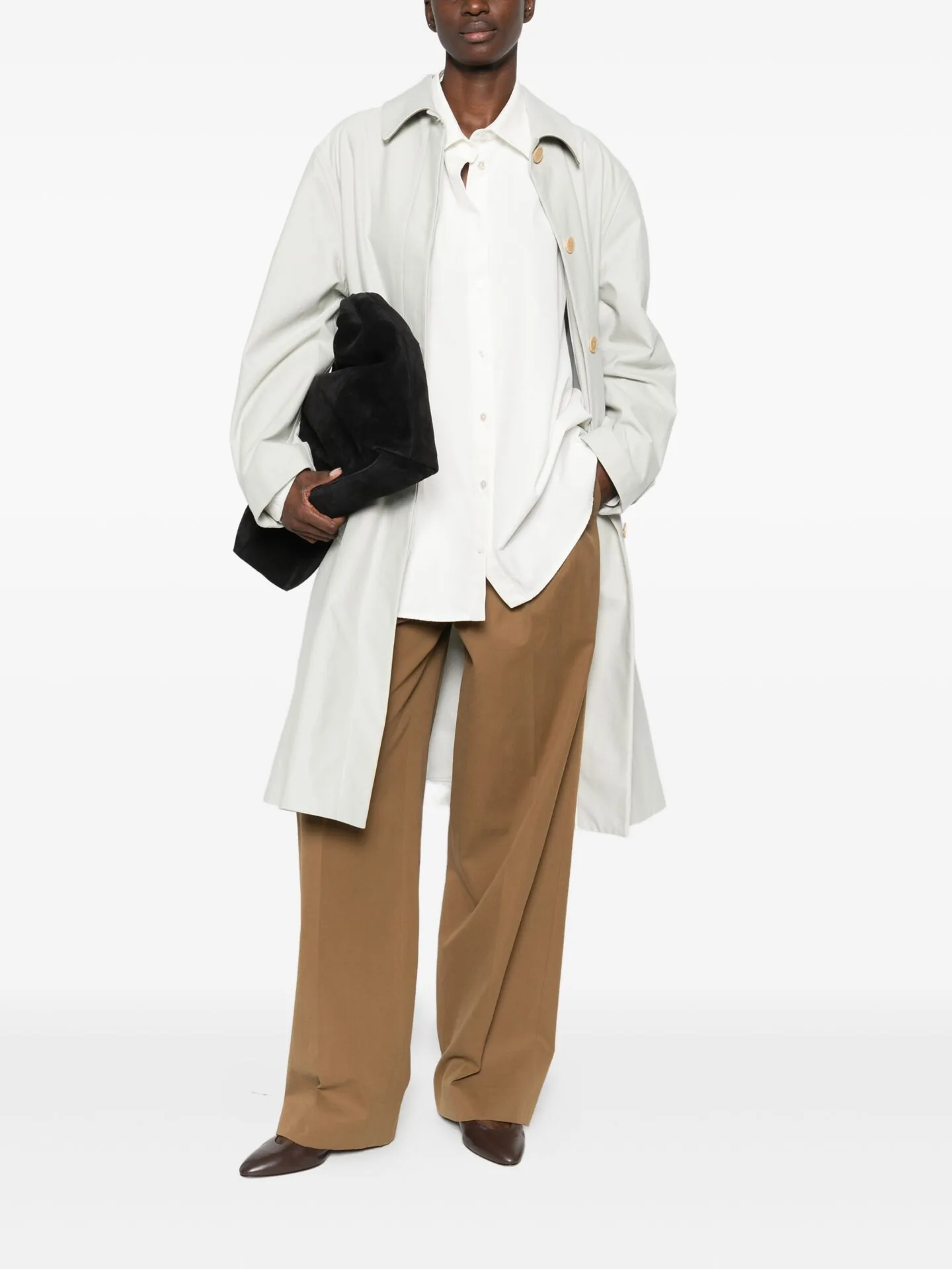 White shirt jacket over tan trousers with a black clutch