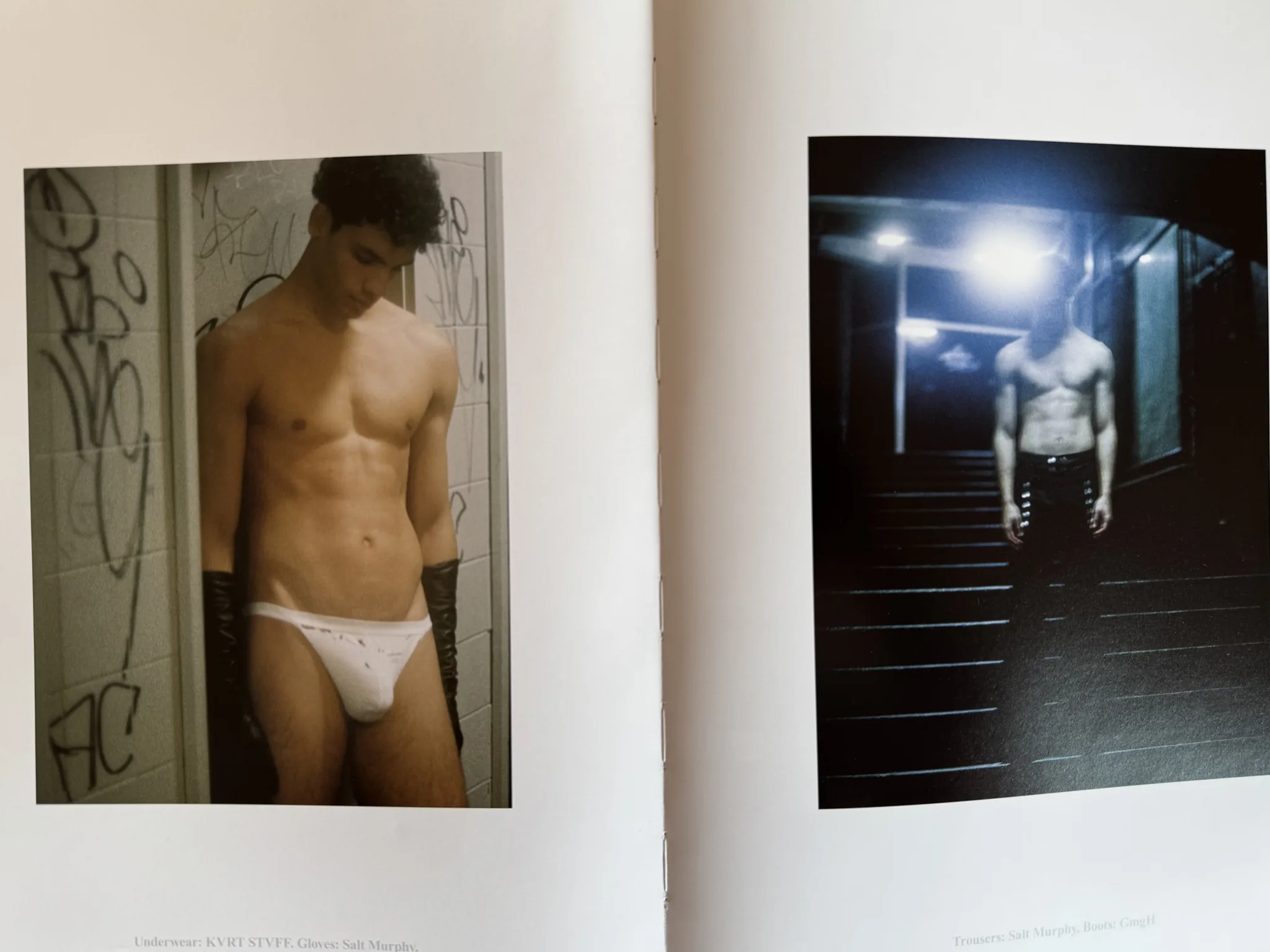 Magazine spread: printed photographs of a model in white briefs against a graffitied wall and a figure on a dark staircase