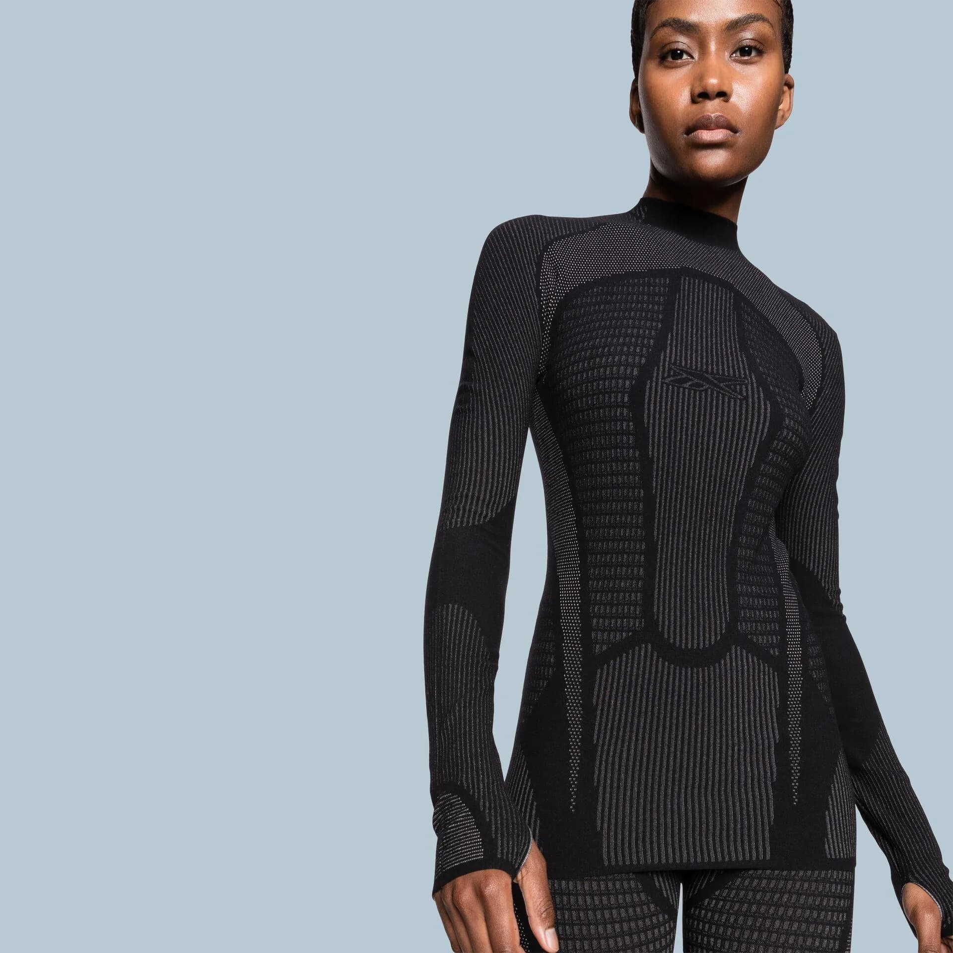 Model in a black ribbed high-neck top with panelled seams